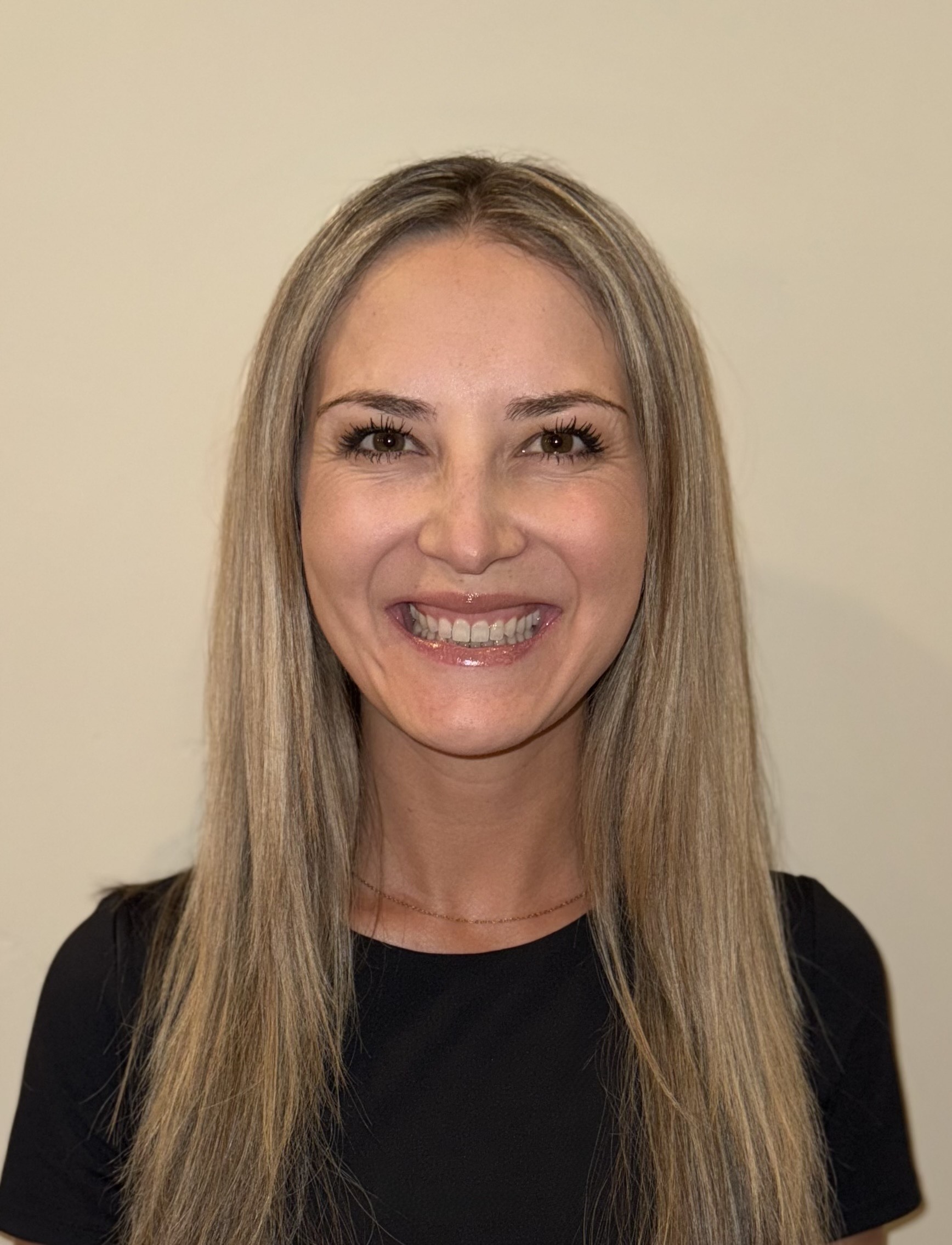 Smiling person with long blonde hair.